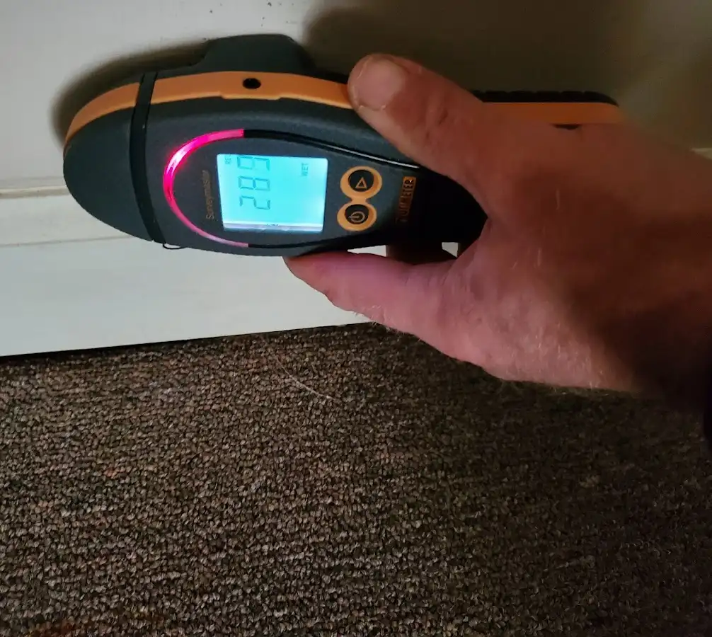Moisture detection at baseboard during Storm Damage Restoration in Bow